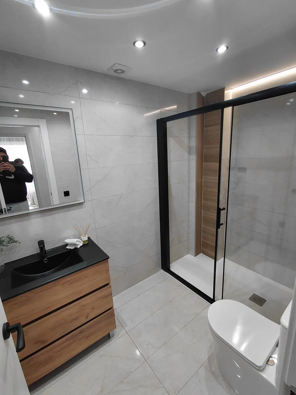 Baño moderno reformado con acabados de madera